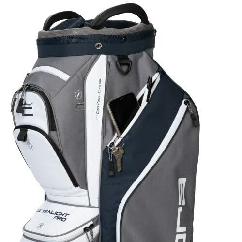 Grey and white golf bag with a pocket holding a smartphone and keys.