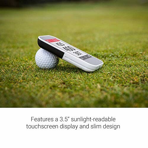 Golf GPS device resting on a golf ball on grass.