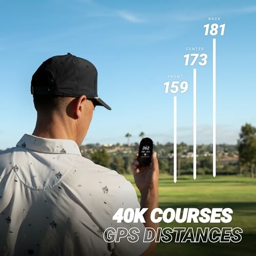 Golfer using GPS device on course with distance markers.