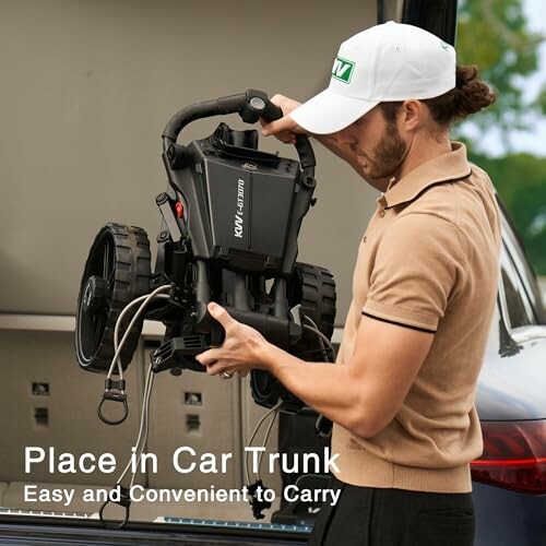 Man placing a portable golf caddy in a car trunk.