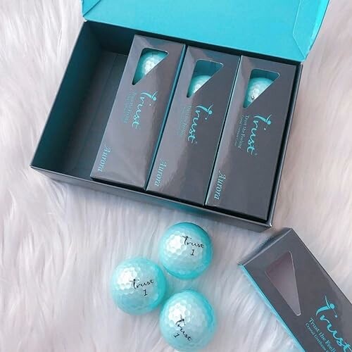 Box of Trust golf balls with three loose balls.